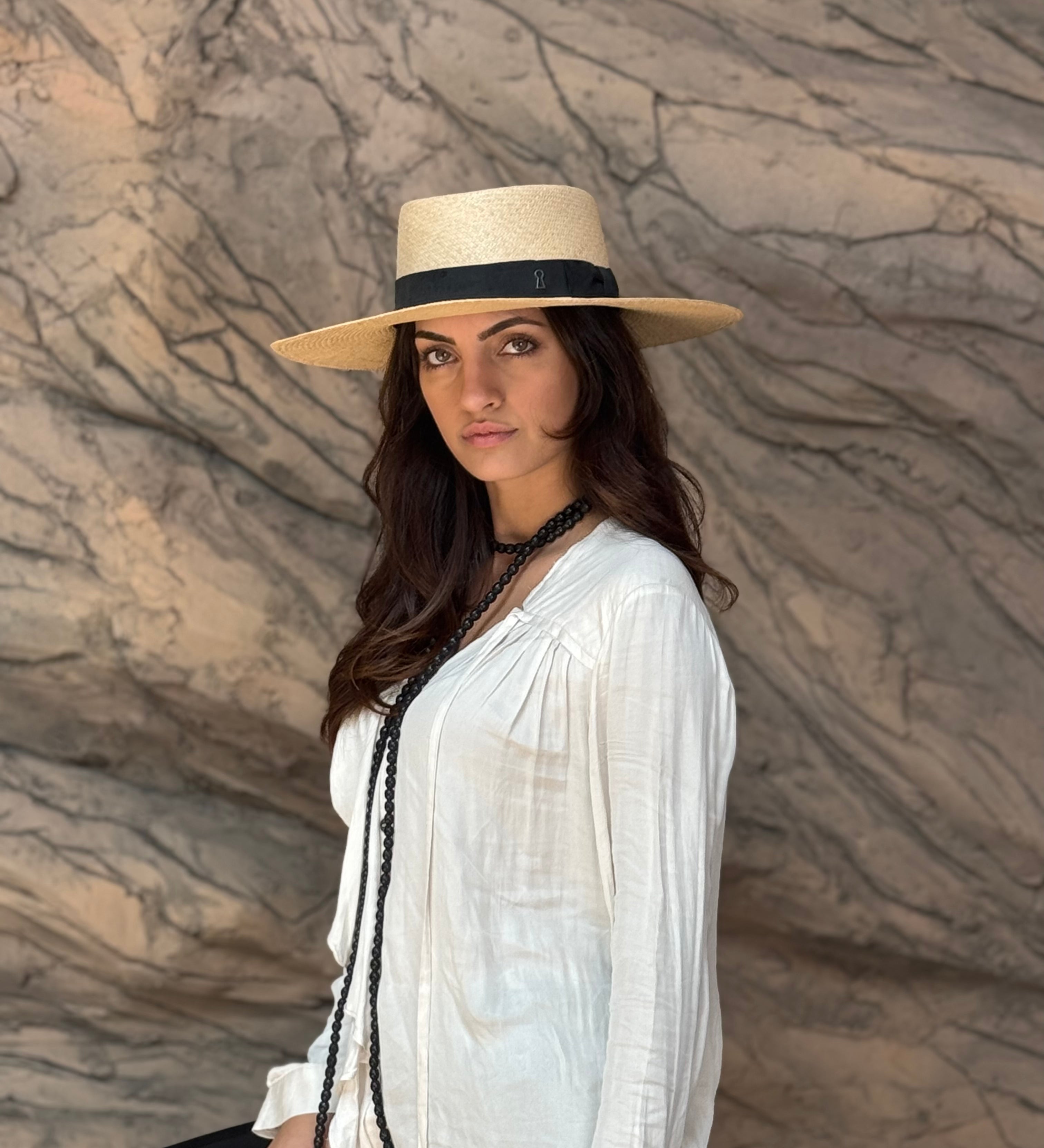 a woman wearing the Wide brim Panama hat in natural Toquilla straw with black ribbon by mister miller