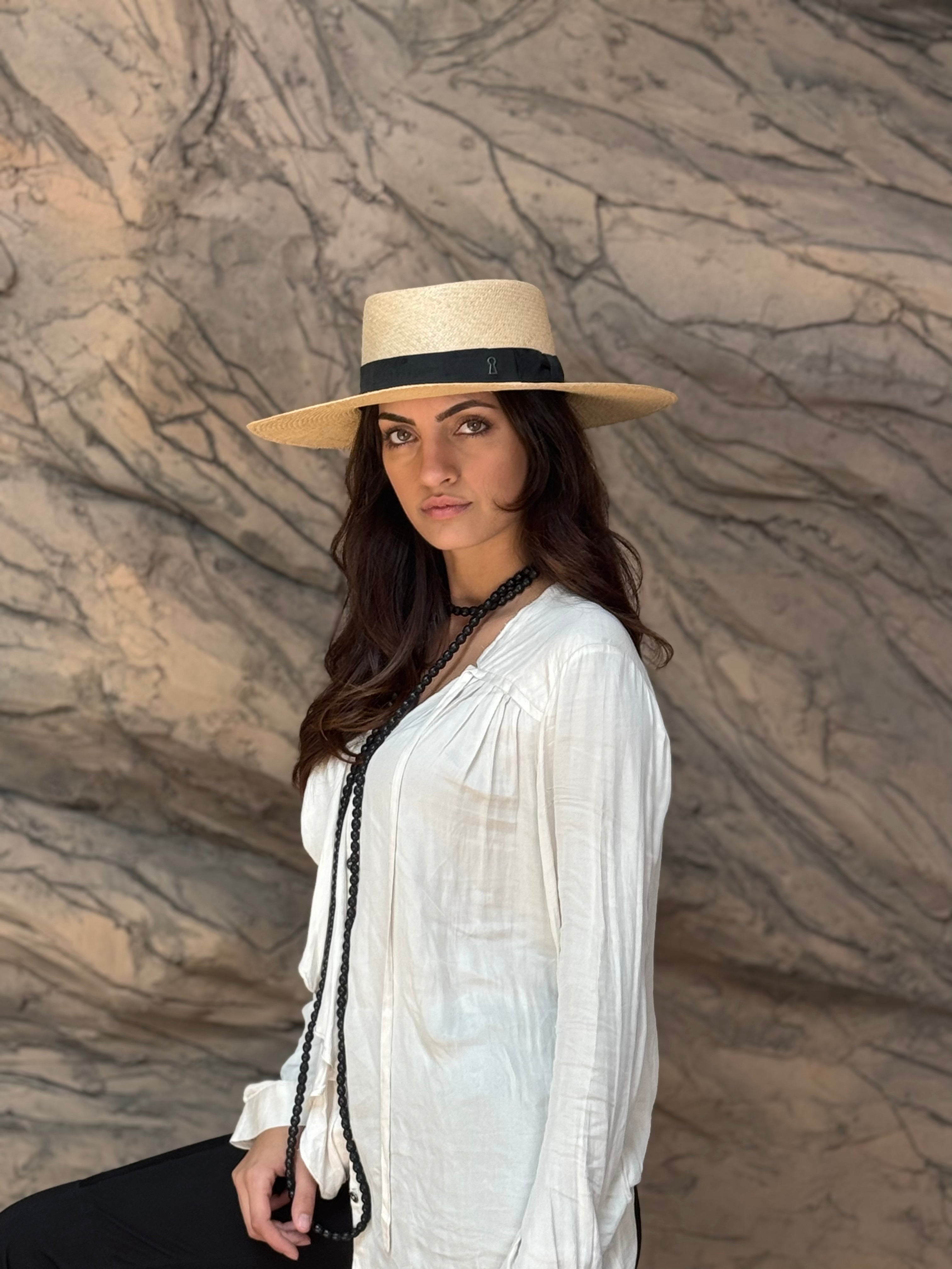 a woman wearing the Wide brim Panama hat in natural Toquilla straw with black ribbon by mister miller