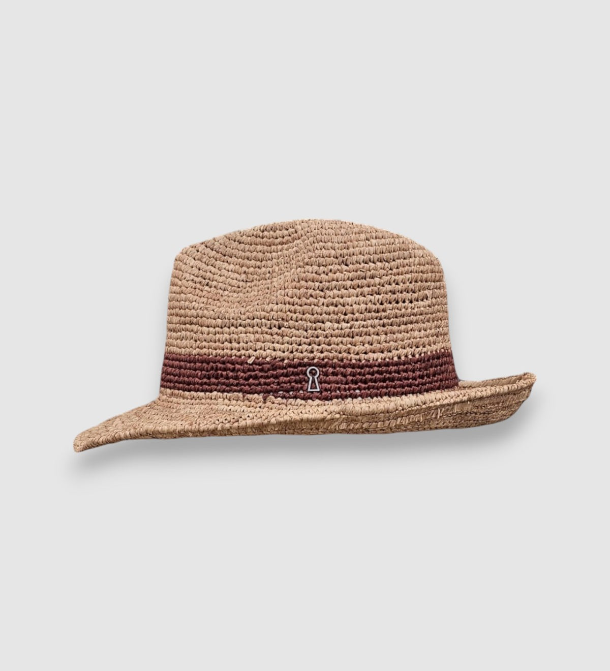 Raffia straw Fedora hat with dark brown woven band and Mister Miller keyhole detail. profile