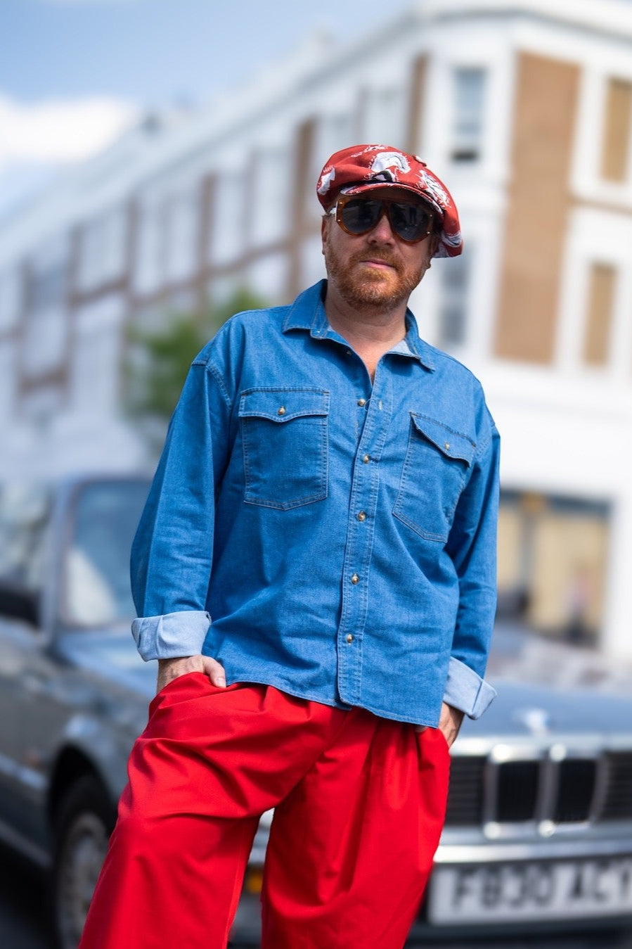 Leigh Francis wearing The Fame — an oversized red Bakerboy cap with 70s-style illustrations, from the Leigh Francis x Mister Miller collection