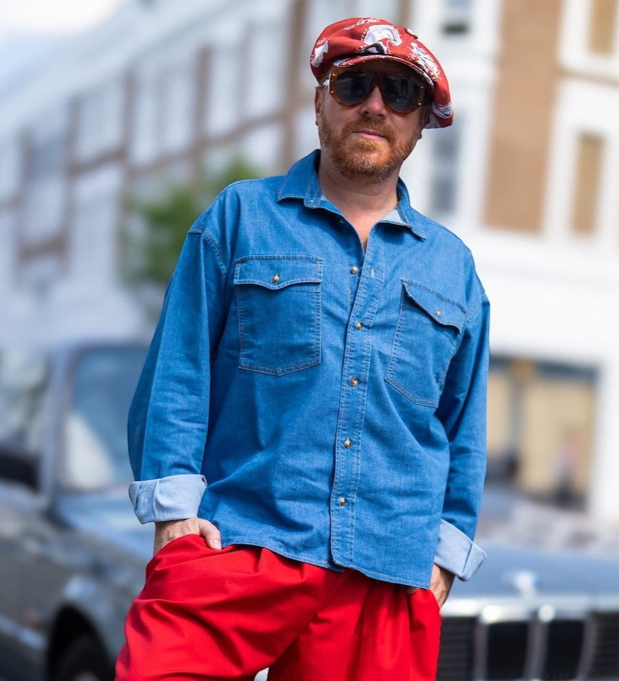 Leigh Francis wearing The Fame — an oversized red Bakerboy cap with 70s-style illustrations, from the Leigh Francis x Mister Miller collection