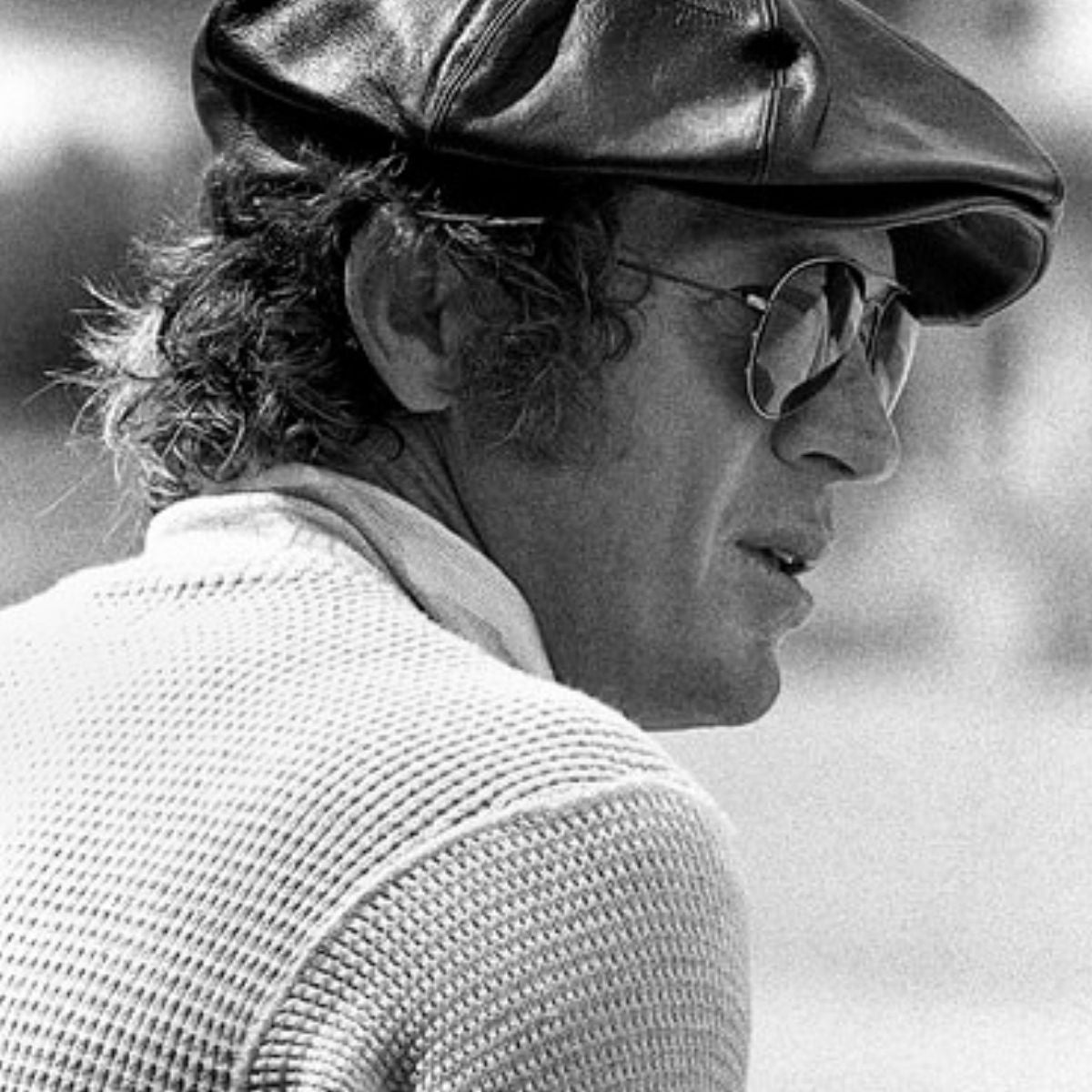 steve mcqueen wearing a black leather bakerboy cap