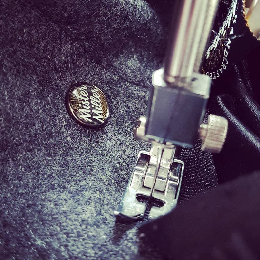 British hatmaking workshop selecting Harris Tweed and luxury wool fabrics for handmade hats