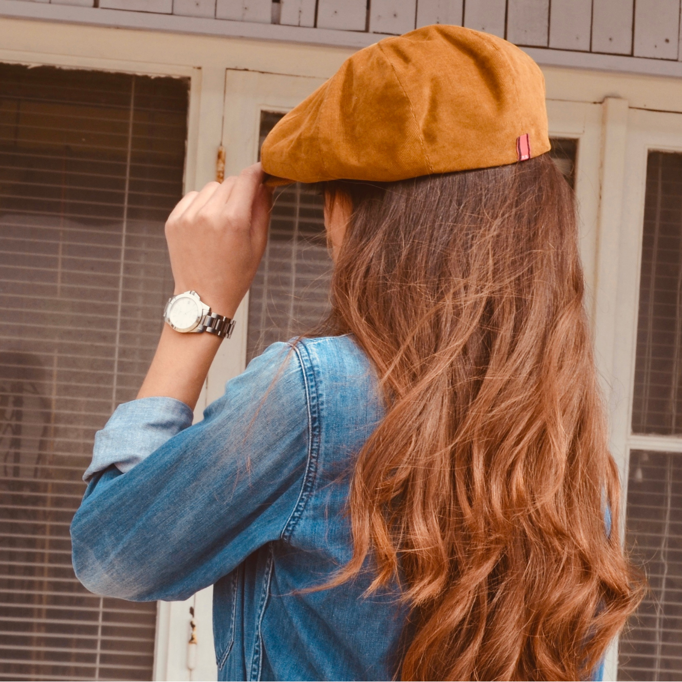 woman wearing a tan fine corduroy newsboy cap