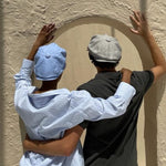 a man and a woman wearing Bakerboy caps in Irish linen herringbone — Riley Skies by Mister Miller, a breathable summer hat handmade in Britain. 