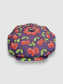Midnight blue oversized Bakerboy cap with bold exploding cherry print — Cherry Pop hat from the Leigh Francis x Mister Miller collection, featuring curved peak and 70s-style swirl lining. front view