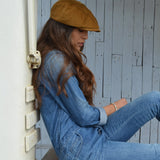 woman in denim with a tan corduroy newsboy cap from mister miller