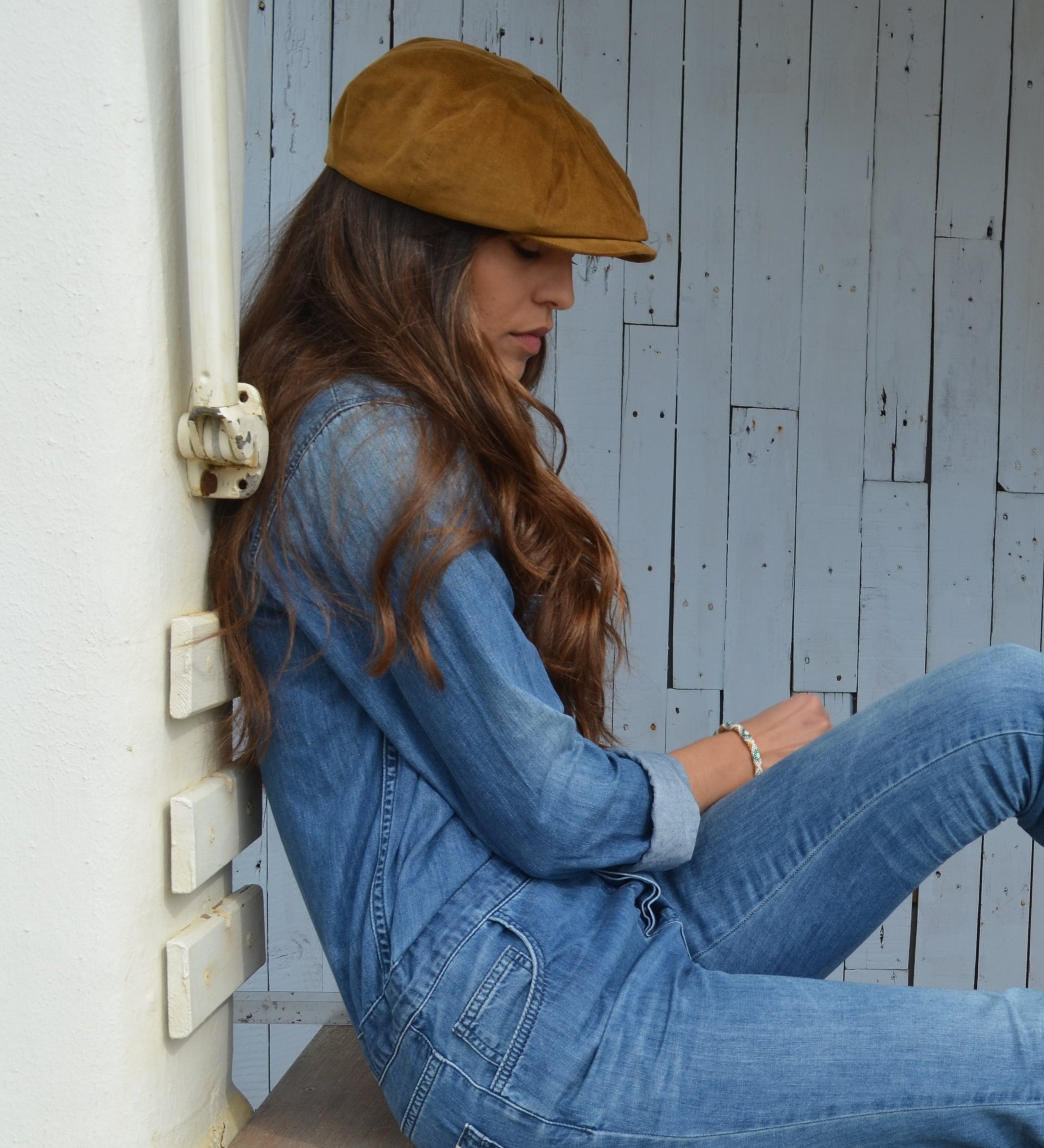 woman in denim with a tan corduroy newsboy cap from mister miller