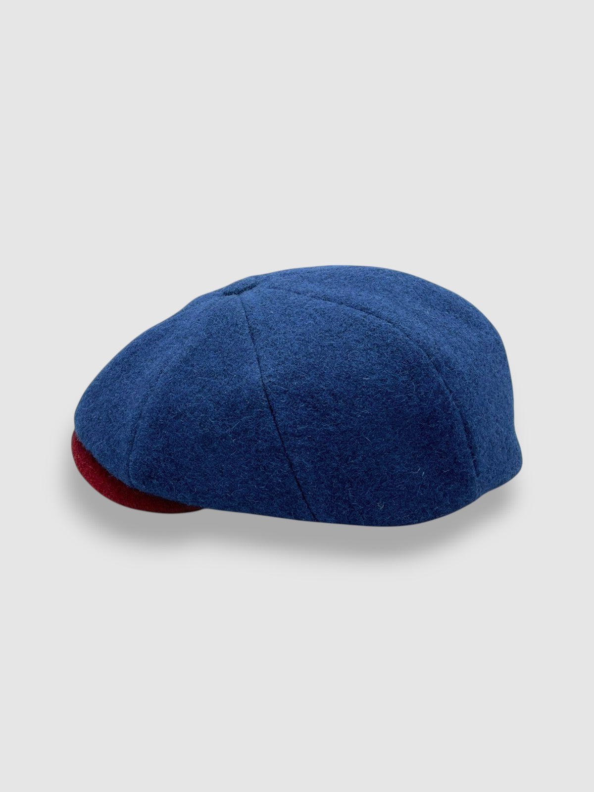 Newsboy cap in teal Melton wool with red and grey contrast peak – Jack’s Steal by Mister Miller. profile view