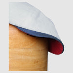 detail shot of the peak of a Slim-cut Newsboy cap in pale blue, red and white linen – Jack’s Sails handmade by Mister Miller
