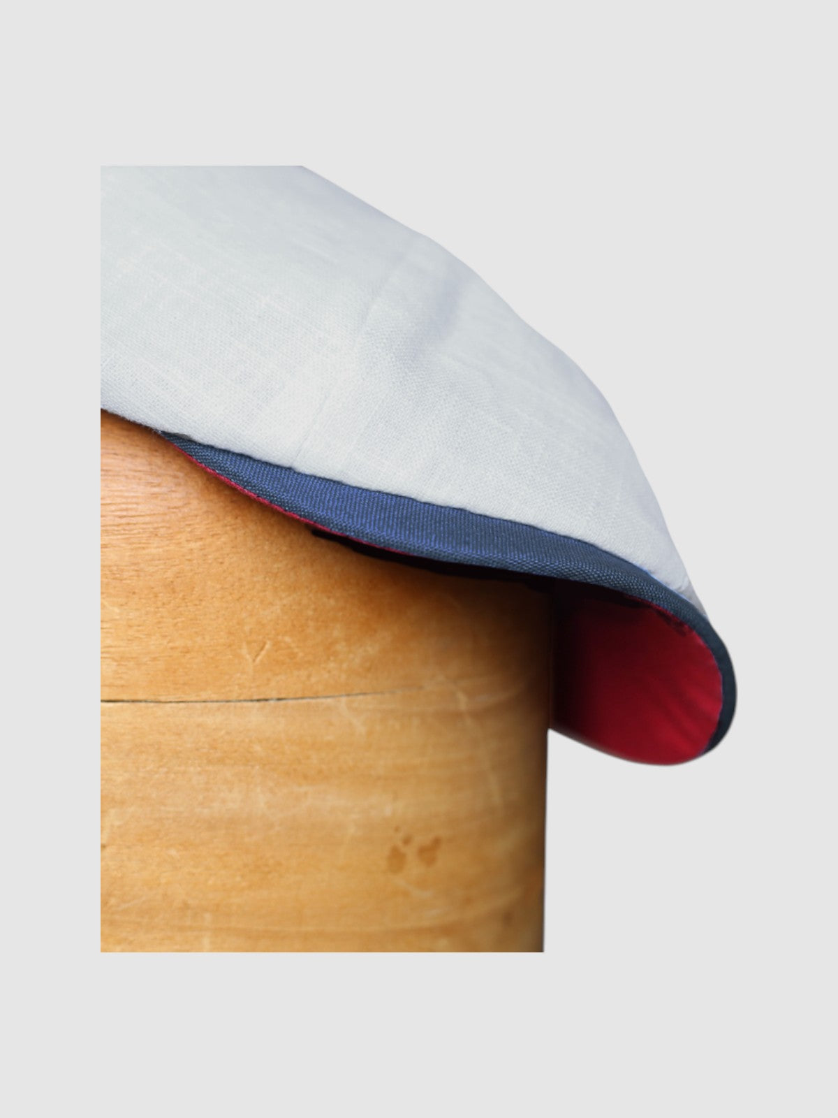 detail shot of the peak of a Slim-cut Newsboy cap in pale blue, red and white linen – Jack’s Sails handmade by Mister Miller