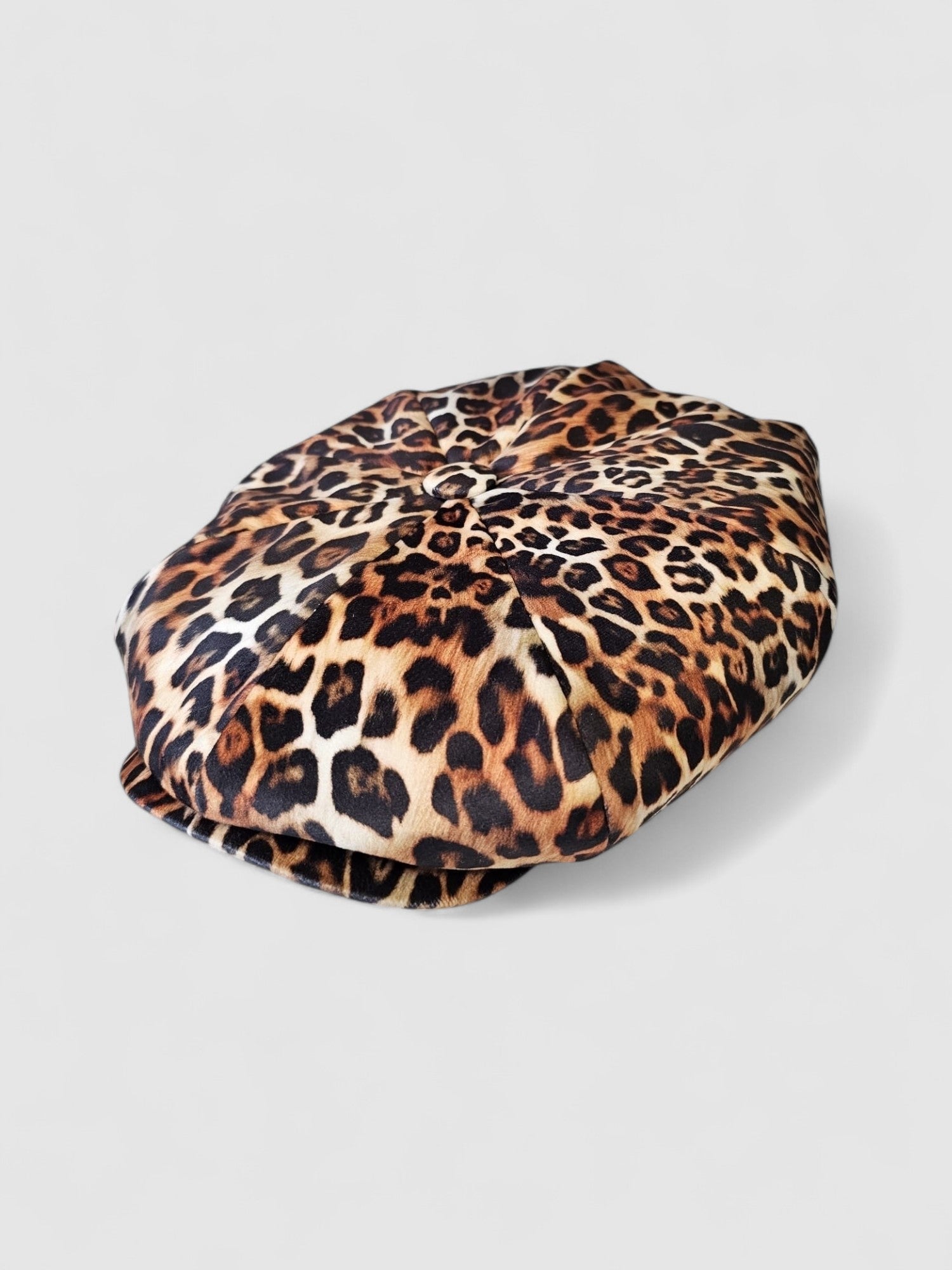 Leopard print velvet Bakerboy cap — oversized silhouette from the Leigh Francis x Mister Miller collection, featuring curved peak, bold 90s style, and signature 70s swirl lining. Side view