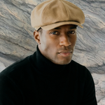 MAN IN BEIGE BAKERBOY CAP