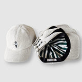 Two baseball caps, one plain and one with a pattern, on a light gray background.
