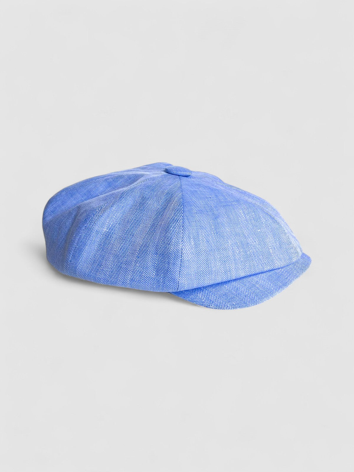 Bakerboy cap in light blue Irish linen herringbone — Riley Skies by Mister Miller, a breathable summer hat handmade in Britain. Profile view
