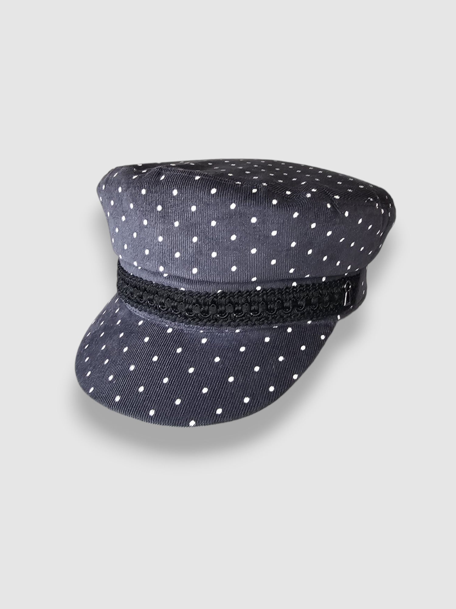 Navy blue cap with white polka dots and a black band on a light gray background