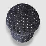 Navy blue cap with white polka dots on a light gray background