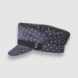 Polka dot cap with a black band featuring a keyhole design on a light gray background
