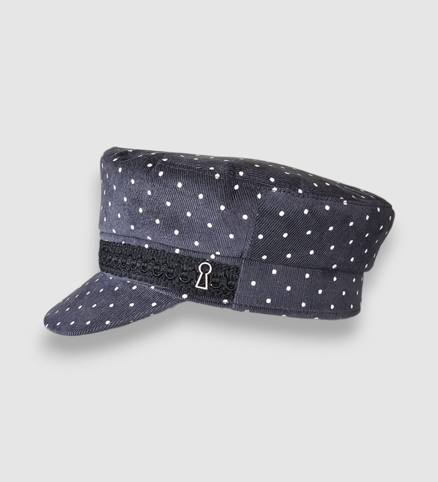 Polka dot cap with a black band featuring a keyhole design on a light gray background