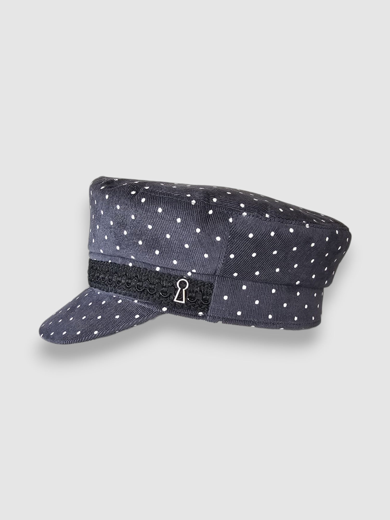 Polka dot cap with a black band featuring a keyhole design on a light gray background