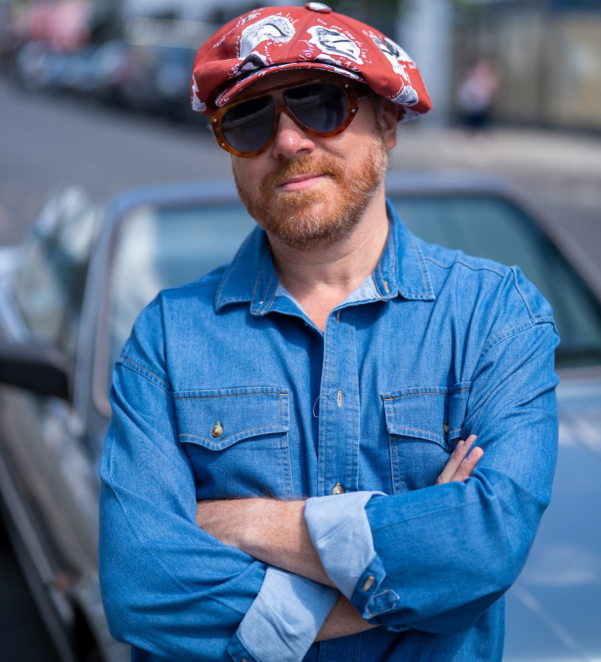 Leigh Francis wearing The Fame — a red oversized Bakerboy cap from his collaboration with Mister Miller, front view. 