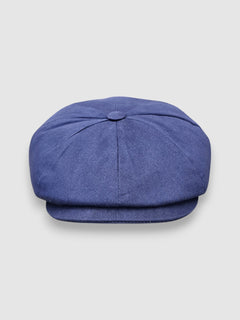 Navy blue waterproof Newsboy cap with ear flaps, handmade in Britain by Mister Miller using breathable coated cotton for cold and wet weather.