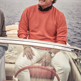 man on a riva boat wearing a newsboy cap with sunglasses