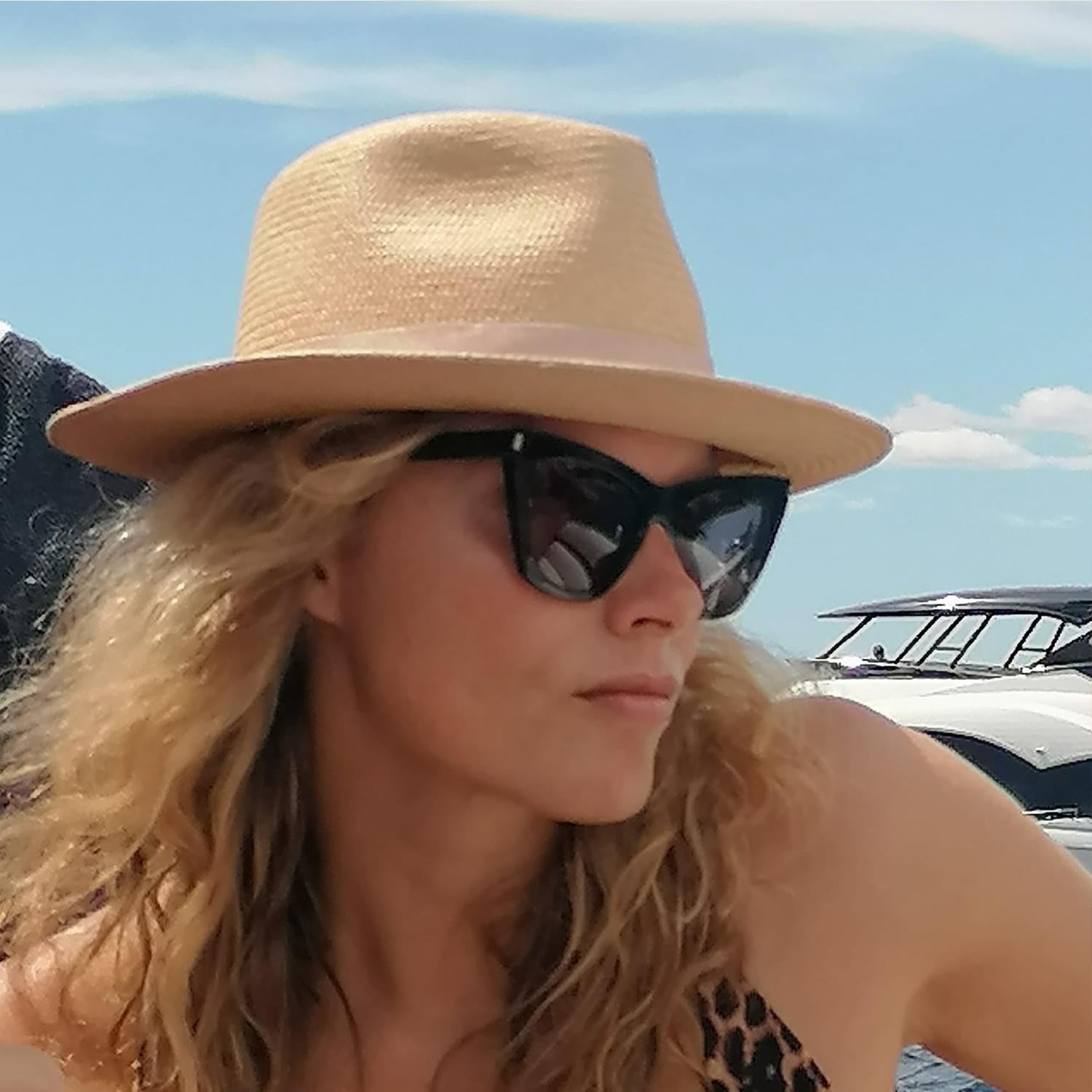 a woman wearing the Cruz Panama hat in handwoven Ecuadorian straw with champagne ribbon, by Mister Miller. profile