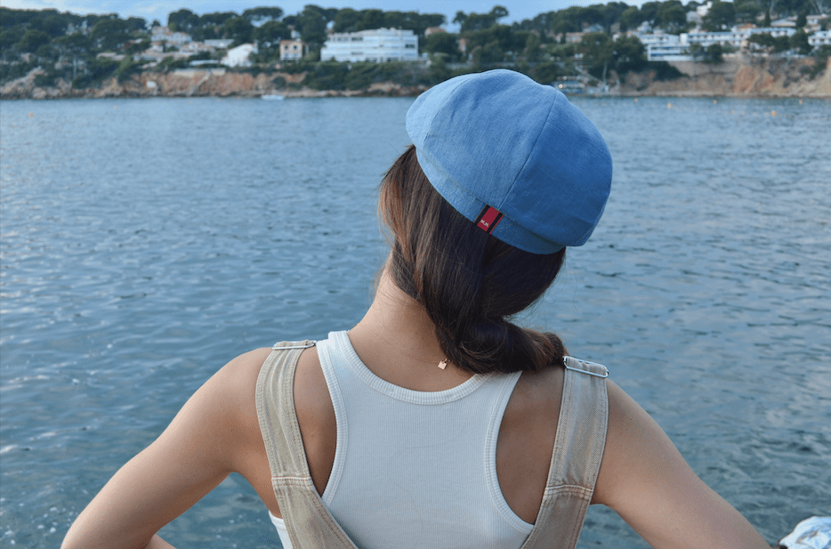 Bakerboy cap in ink-blue washed linen — Albert’s Wave, modern folded headband detail, handmade by Mister Miller. worn by a woman. rear view.